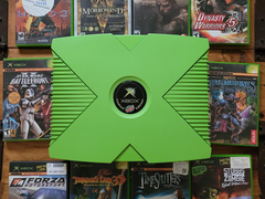 Una Xbox di colore verde con 10 titoli Xbox retrò raffigurati