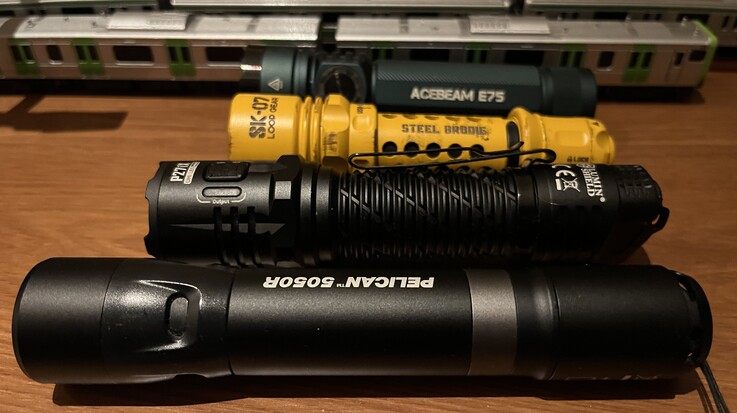 Il modello SK-07 giallo di Loop Gear a confronto con l’Acebeam E75 (sul retro), il Nitecore P27i e il Pelican 5050R