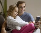 Un padre e sua figlia che guardano insieme uno smartphone