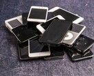 Mucchio di smartphone fuori uso su una superficie grigia