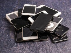 Mucchio di smartphone fuori uso su una superficie grigia