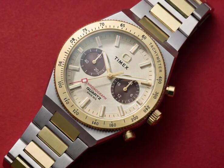 Primo piano del cronografo Timex Q Timex Continental TW2Y92300 indossato al polso, che mostra il quadrante color oro, i quadranti secondari marroni, la lunetta tachimetrica e il bracciale bicolore in acciaio inossidabile.