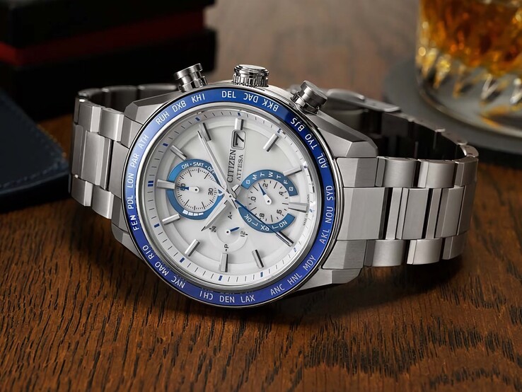 Cronografo Citizen Attesa AT8297-51L appoggiato su un tavolo di legno, con quadrante blu navy, dettagli color oro rosa e lunetta nera con indicazione dell’ora mondiale.