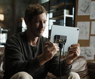 Utente che collega l'SSD portatile trasparente Sharge Disk Pro con raffreddamento attivo a un tablet tramite cavo USB-C. (Sharge via Kickstarter)