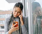 Una donna guarda il proprio smartphone con espressione seria