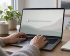 Le mani sulla tastiera di un computer portatile, un cursore all’estrema sinistra dello schermo