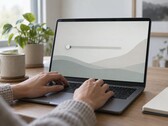 Le mani sulla tastiera di un computer portatile, un cursore all’estrema sinistra dello schermo