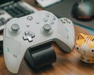 Un controller Xbox bianco appoggiato su una scrivania di legno accanto a una statuetta di gatto (Fonte immagine: FOX ^.ᆽ.^= ∫ via Pexels)