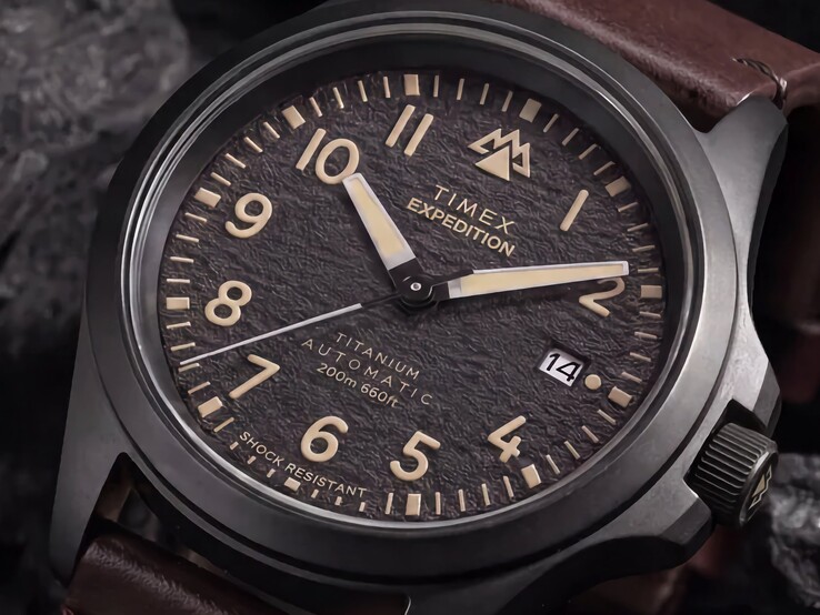 Primo piano del quadrante nero testurizzato del Timex Expedition Field Post Titanium con numeri arabi, lancette e indici luminescenti e datario.